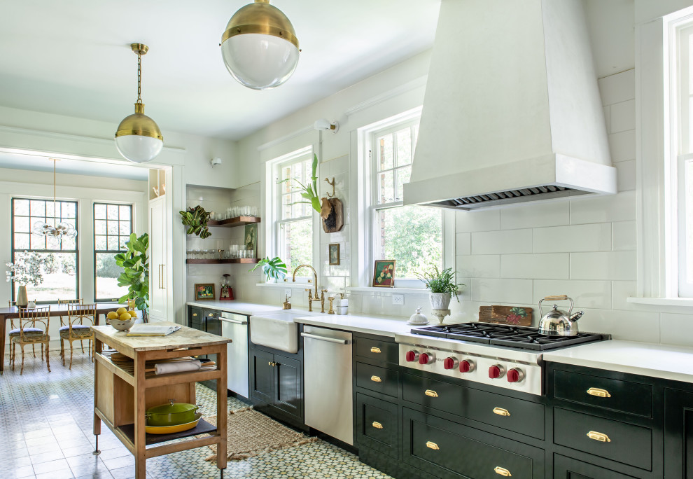 Exempel på ett klassiskt vit vitt kök, med en rustik diskho, skåp i shakerstil, svarta skåp, vitt stänkskydd, rostfria vitvaror, en köksö och flerfärgat golv