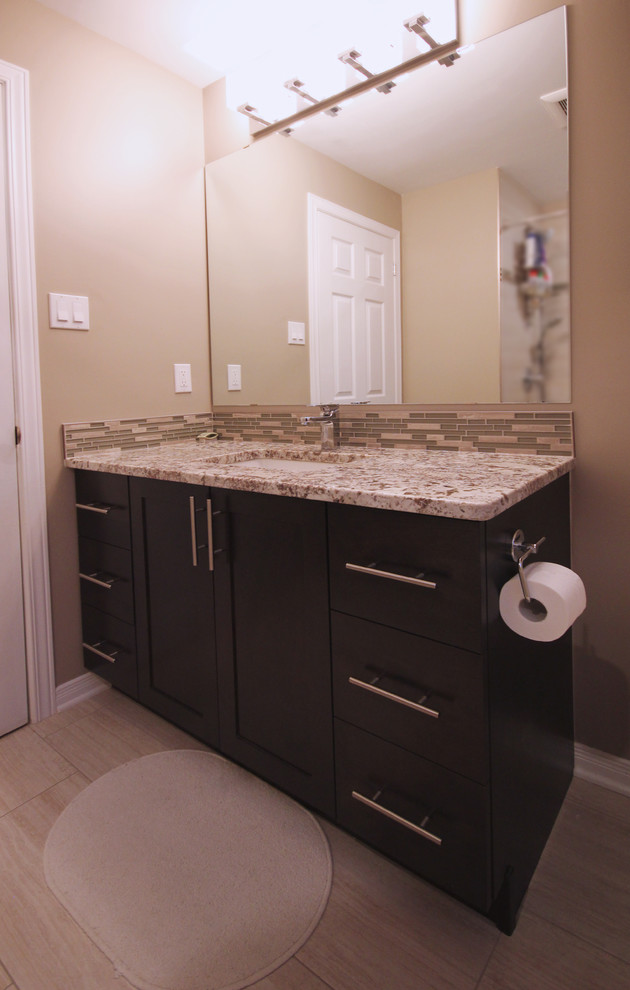 This is an example of a mid-sized contemporary master bathroom in Ottawa with recessed-panel cabinets, dark wood cabinets, granite benchtops, beige tile, ceramic tile, a corner tub, a corner shower, a one-piece toilet, an undermount sink, beige walls and ceramic floors.