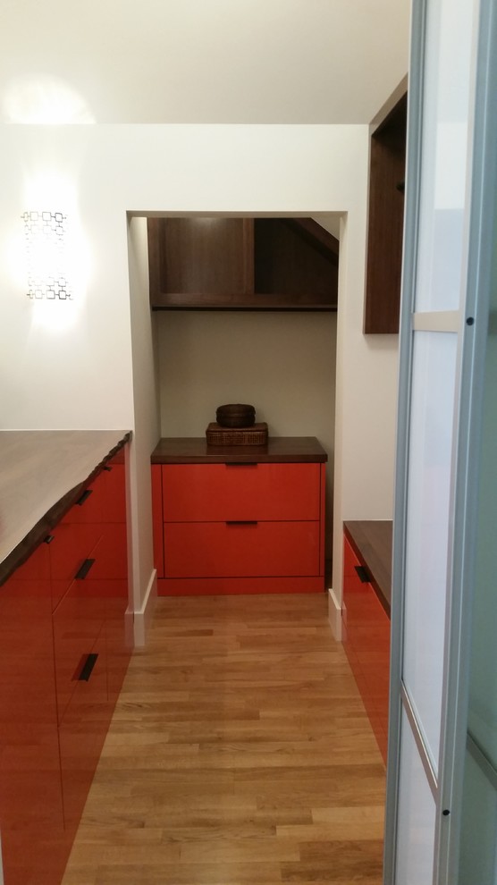Mid-sized modern storage and wardrobe in San Francisco with flat-panel cabinets and orange cabinets.