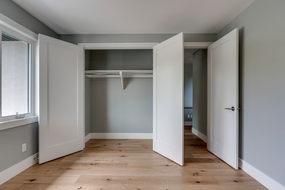 Example of a mid-sized transitional guest light wood floor and brown floor bedroom design in Calgary with gray walls