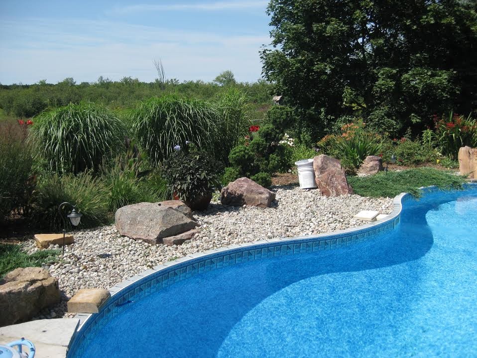 This is an example of a large transitional backyard stone landscaping in Ottawa.