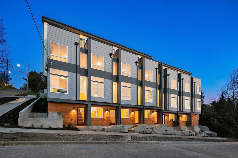 Geräumiges, Vierstöckiges Modernes Reihenhaus mit Vinylfassade, weißer Fassadenfarbe, Flachdach, Misch-Dachdeckung, weißem Dach und Verschalung in Seattle