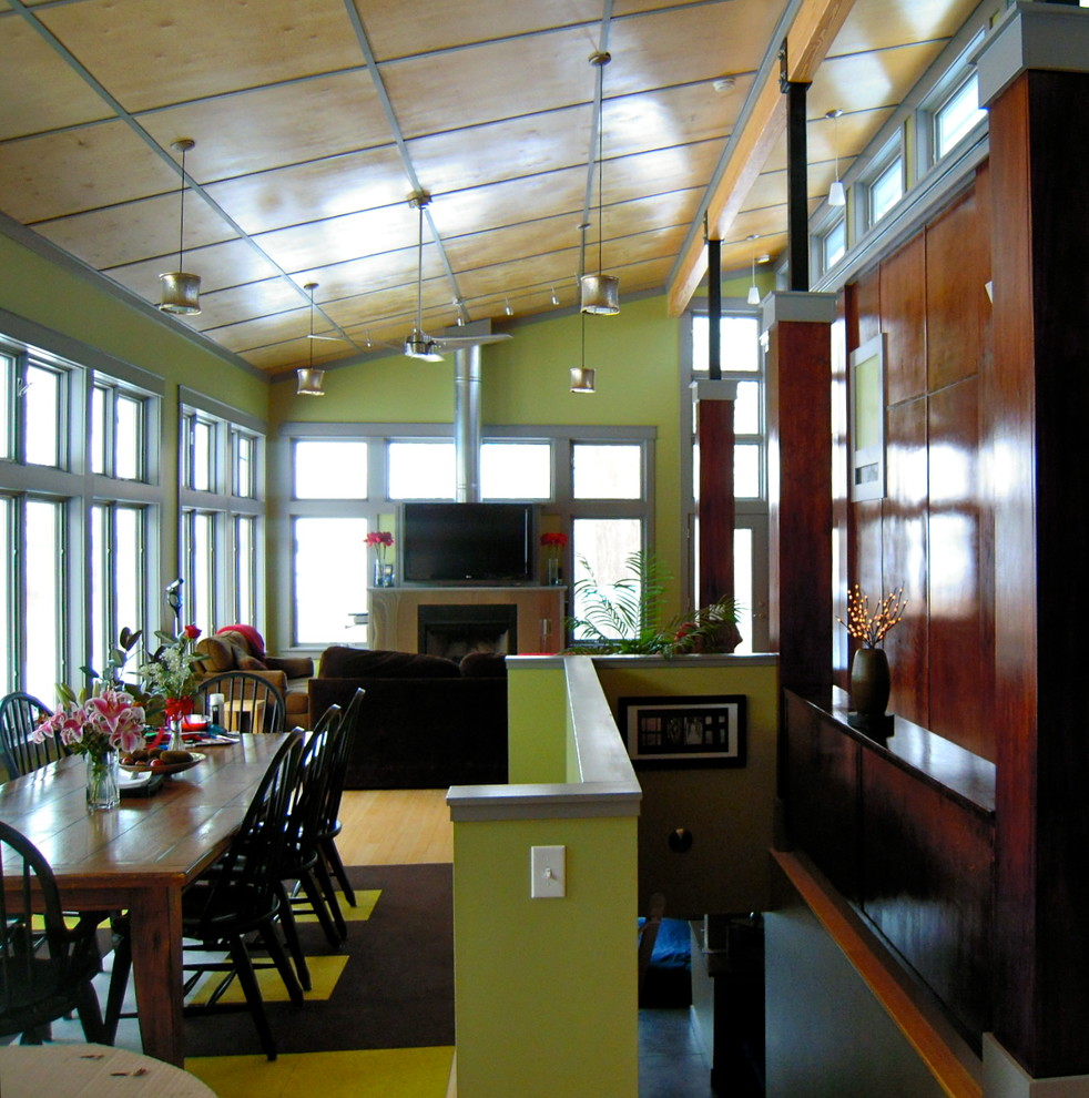 Photo of an expansive contemporary open plan dining in Indianapolis with green walls and light hardwood floors.
