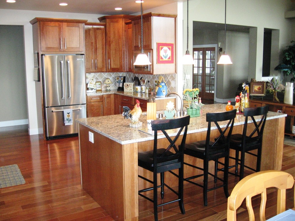 Inspiration for a transitional kitchen remodel in Seattle with an undermount sink, shaker cabinets, granite countertops, beige backsplash, stone tile backsplash and an island