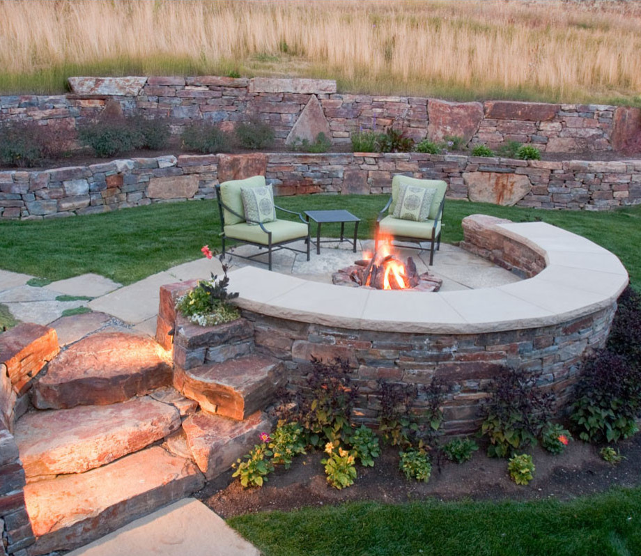 This is an example of a small backyard patio in Boise with a fire feature, natural stone pavers and no cover.