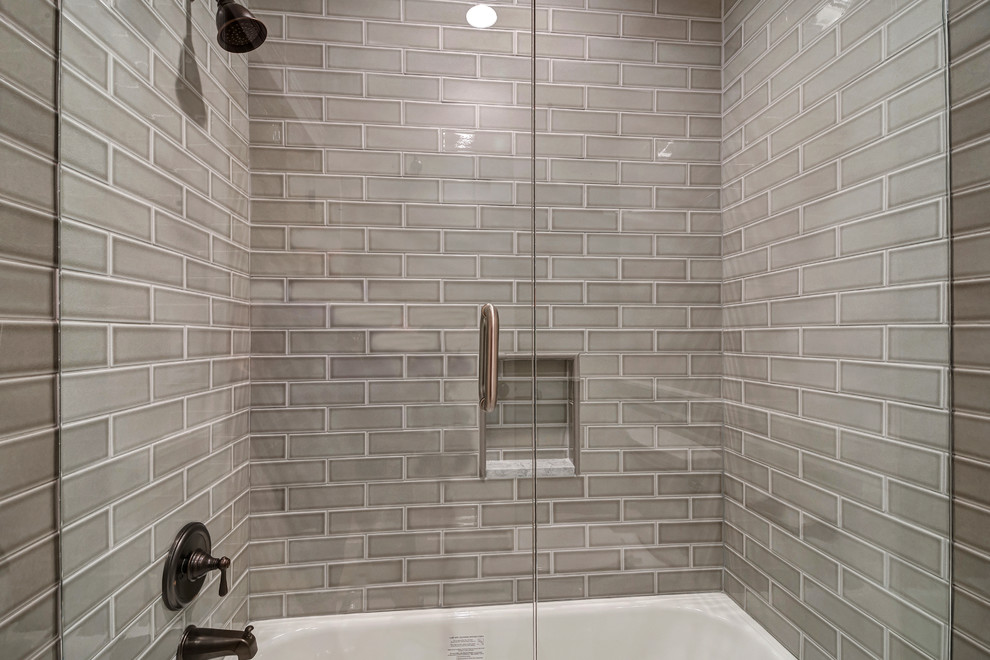 This is an example of a mid-sized transitional 3/4 bathroom in Salt Lake City with shaker cabinets, white cabinets, an alcove shower, a two-piece toilet, beige tile, porcelain tile, beige walls, marble floors, an undermount sink, marble benchtops, white floor, a hinged shower door and white benchtops.