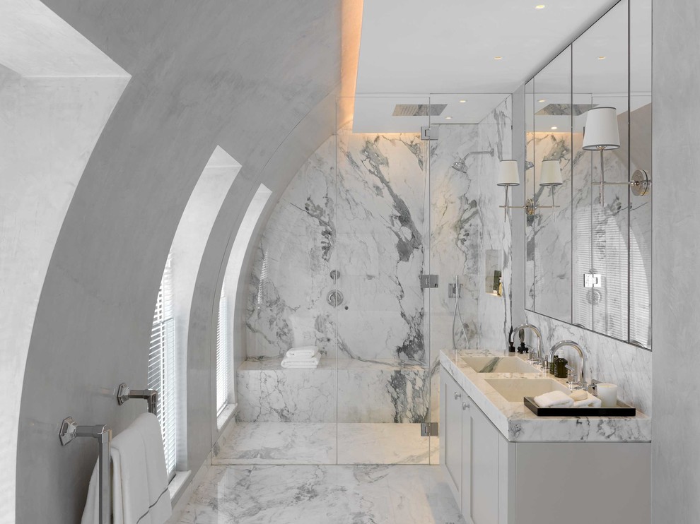 This is an example of a mid-sized contemporary 3/4 wet room bathroom in London with marble, white walls, marble floors, marble benchtops, white floor, a hinged shower door, shaker cabinets, white cabinets, gray tile, white tile and an integrated sink.