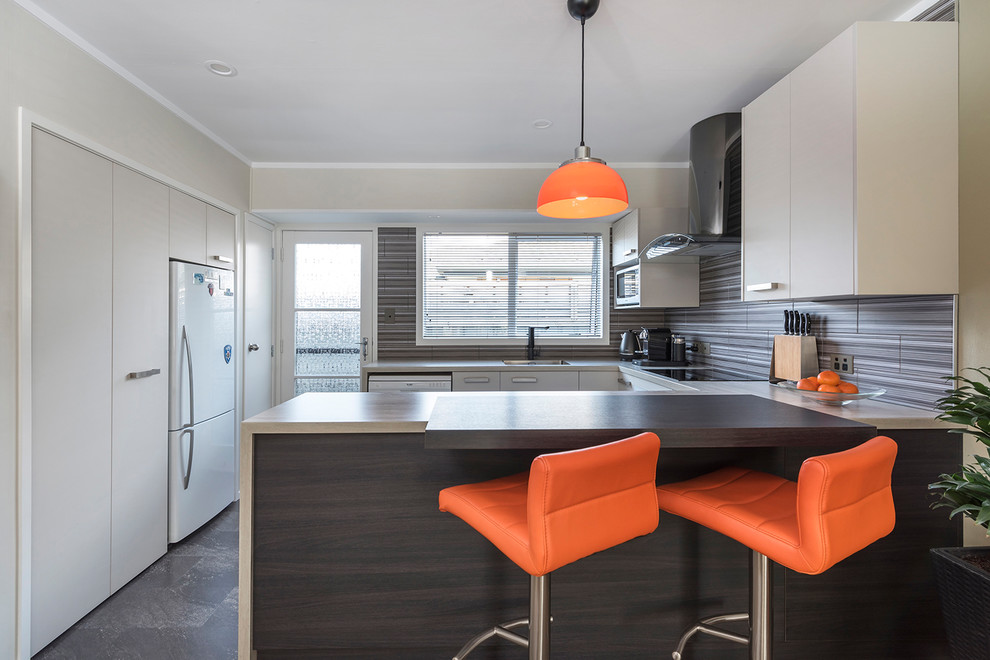 Photo of a small contemporary u-shaped eat-in kitchen in Auckland with an undermount sink, flat-panel cabinets, beige cabinets, a peninsula, laminate benchtops, multi-coloured splashback, ceramic splashback, white appliances, ceramic floors and multi-coloured floor.
