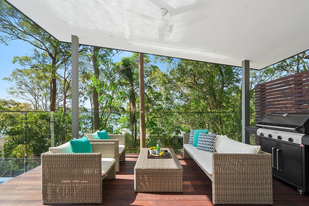 This is an example of a contemporary backyard deck in Sunshine Coast with a roof extension.