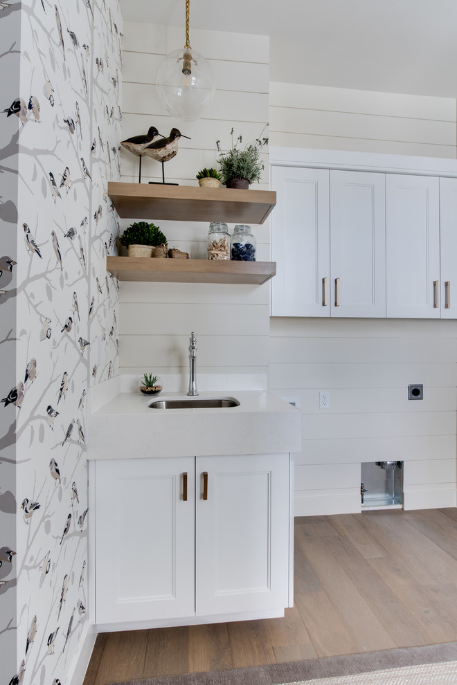 Inspiration for a country single-wall utility room in Salt Lake City with an undermount sink, light hardwood floors, a side-by-side washer and dryer, shaker cabinets, white cabinets, quartzite benchtops, multi-coloured walls and white benchtop.
