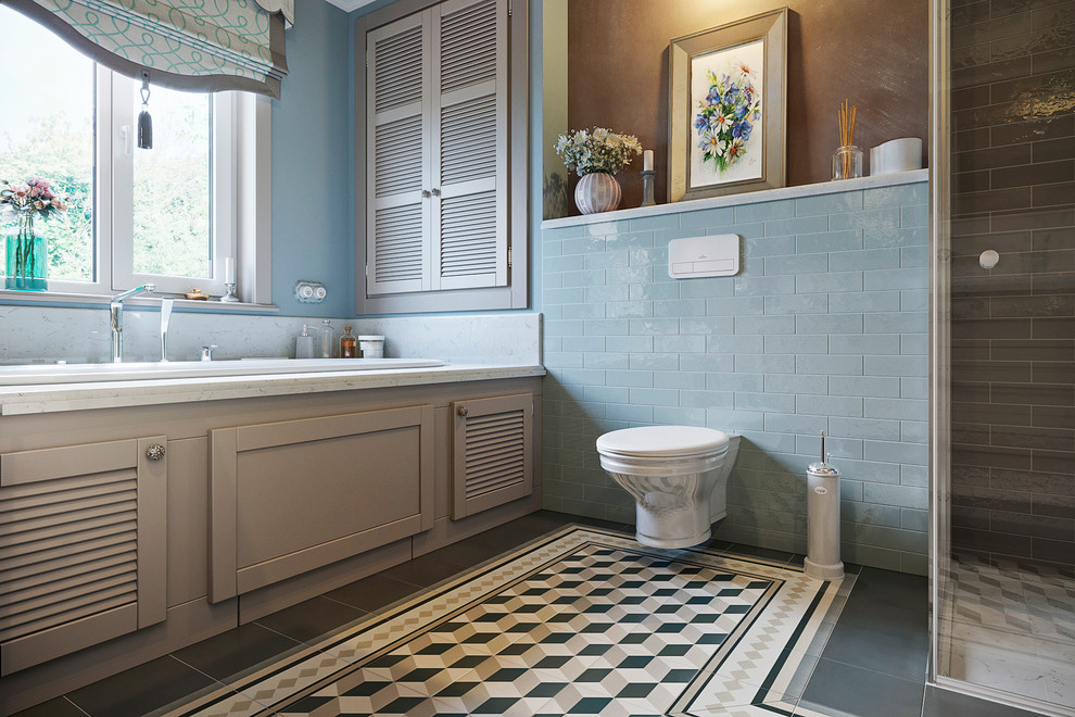 Design ideas for a mid-sized country 3/4 bathroom in Moscow with louvered cabinets, distressed cabinets, a drop-in tub, a curbless shower, a wall-mount toilet, blue tile, ceramic tile, blue walls, ceramic floors, an undermount sink, marble benchtops, brown floor, a hinged shower door and beige benchtops.