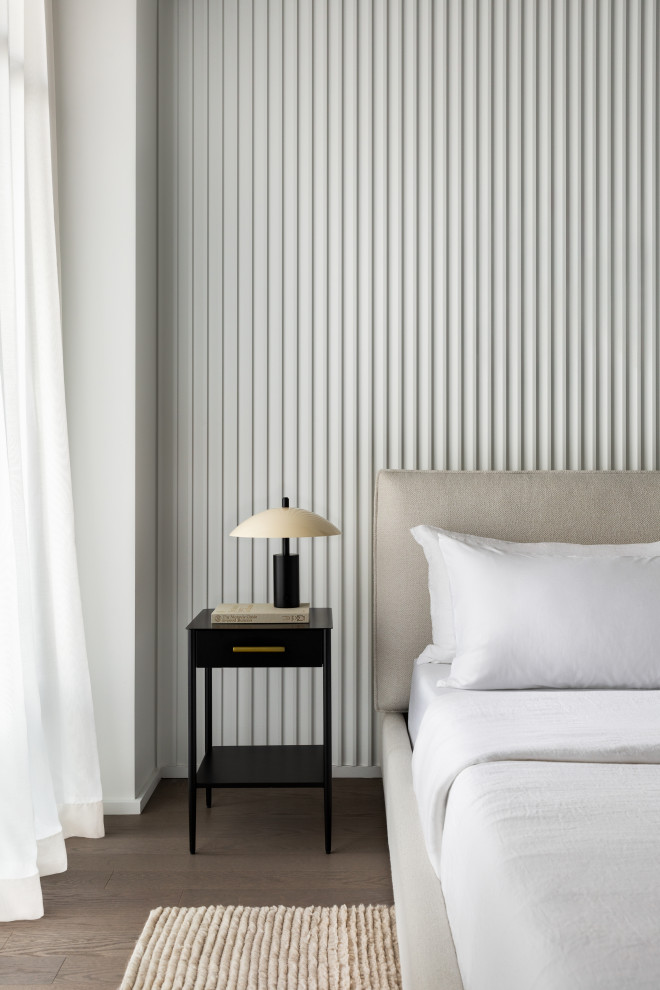 Mittelgroßes Modernes Hauptschlafzimmer mit weißer Wandfarbe, braunem Holzboden, braunem Boden und Wandpaneelen in New York