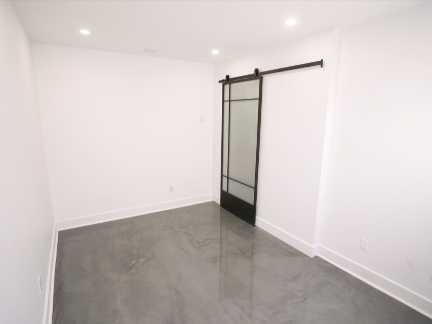 This is an example of a small contemporary home studio in Chicago with white walls, concrete flooring and grey floors.