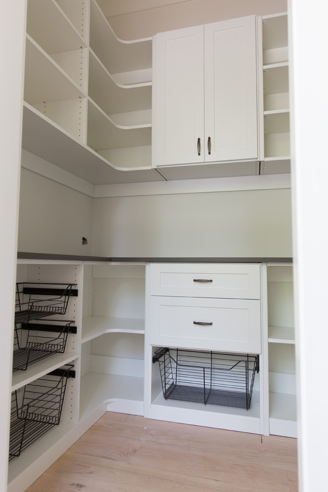 Mid-sized arts and crafts u-shaped kitchen pantry in Atlanta with shaker cabinets, white cabinets, laminate benchtops, light hardwood floors, no island, brown floor and brown benchtop.