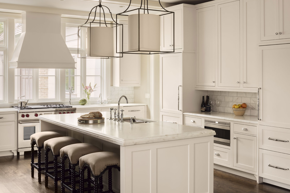 Inspiration for a timeless l-shaped dark wood floor and brown floor kitchen remodel in Milwaukee with an undermount sink, shaker cabinets, white cabinets, white backsplash, paneled appliances and an island