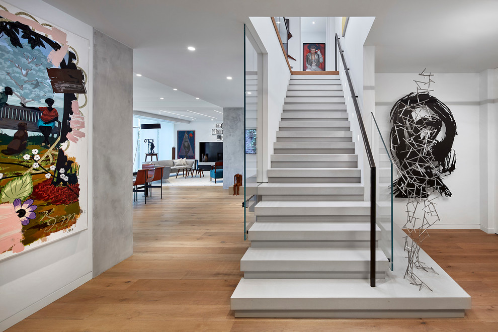 This is an example of an eclectic concrete straight staircase in Toronto with concrete risers and mixed railing.