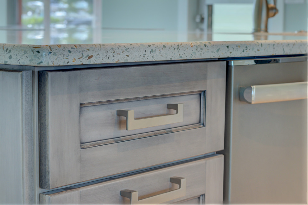 Example of a large transitional l-shaped ceramic tile and gray floor home design design with an undermount sink, shaker cabinets, white cabinets, recycled glass countertops, blue backsplash, glass tile backsplash, stainless steel appliances, an island and white countertops