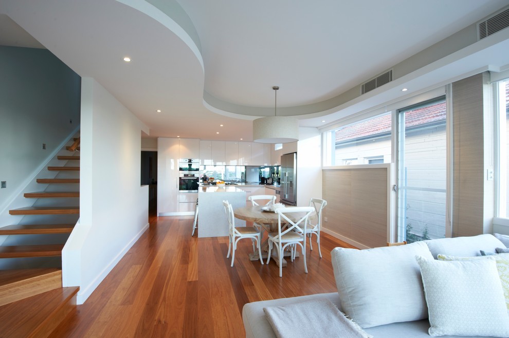 Inspiration for a mid-sized contemporary kitchen/dining combo in Sydney with white walls and medium hardwood floors.