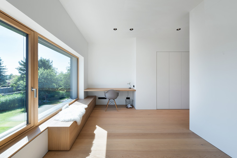 Photo of an expansive scandinavian master bedroom in Munich with white walls, light hardwood floors and brown floor.