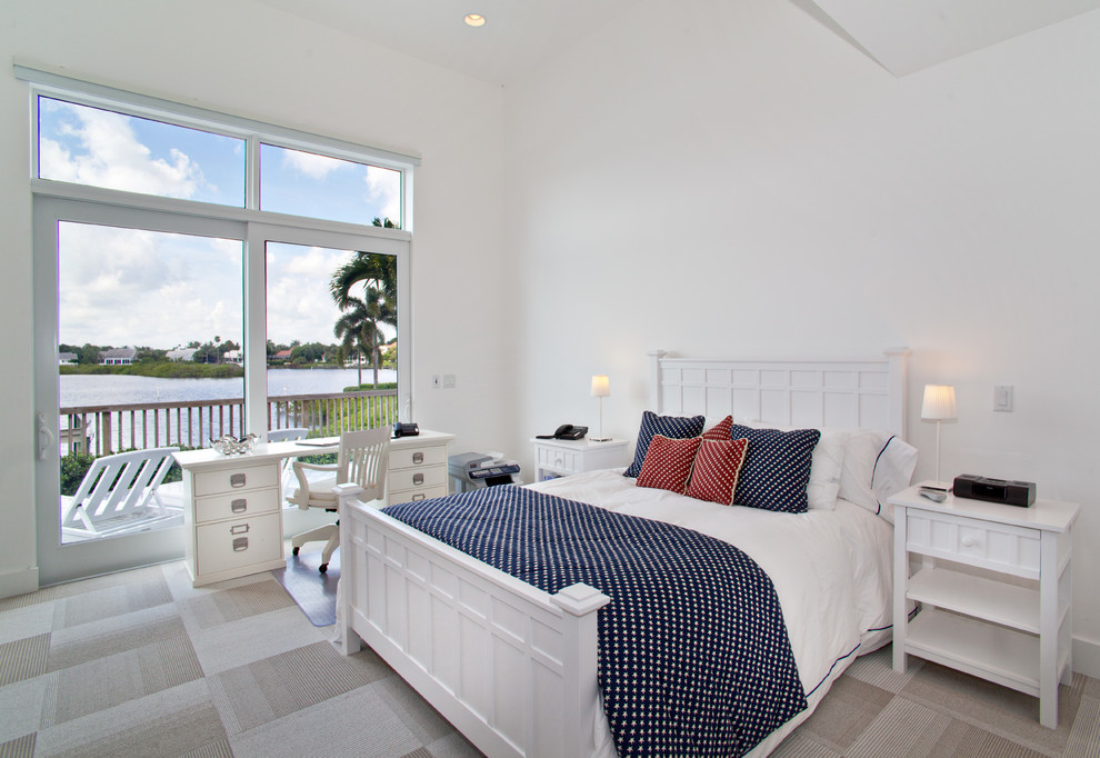 This is an example of a mid-sized beach style guest bedroom in Miami with white walls, carpet and no fireplace.