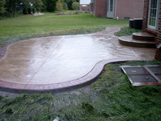Photo of a large backyard patio in Detroit with stamped concrete.