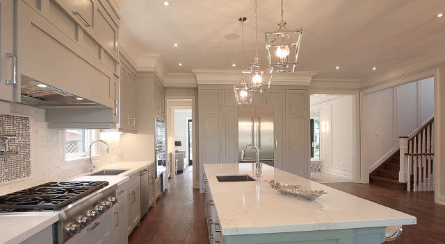 Large transitional galley medium tone wood floor kitchen pantry photo in Toronto with an undermount sink, shaker cabinets, gray cabinets, quartz countertops, white backsplash, mosaic tile backsplash, stainless steel appliances and an island
