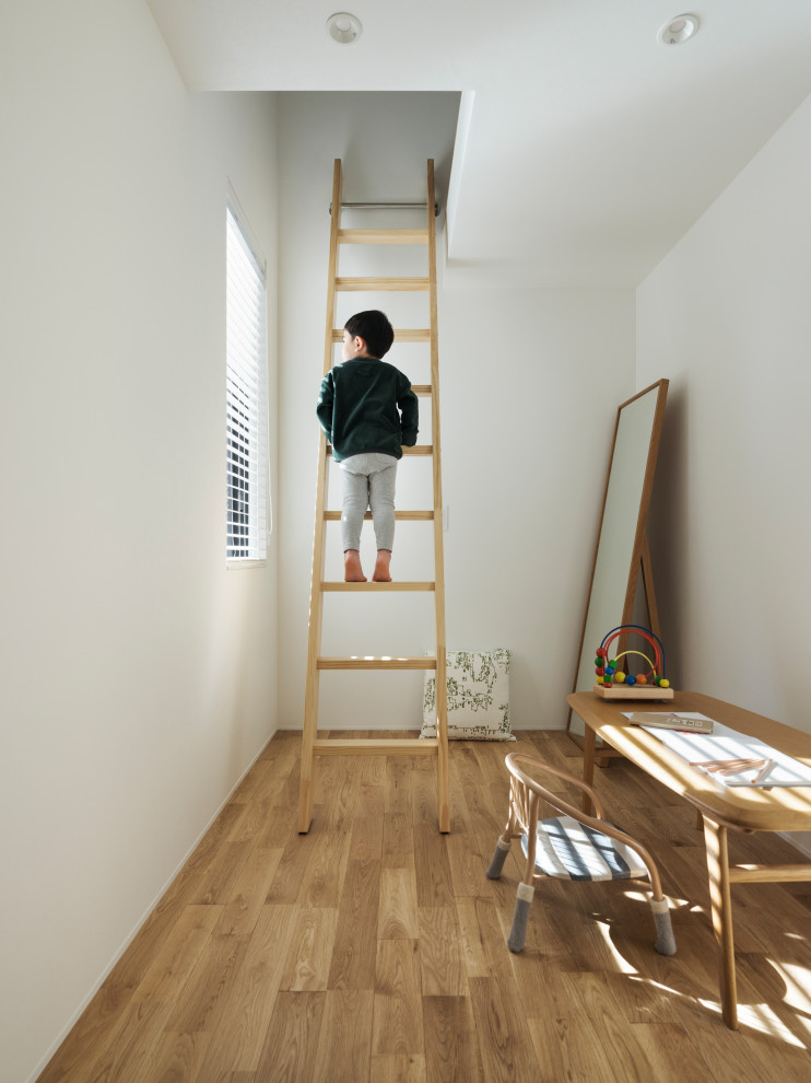 Ejemplo de habitación de niño nórdica pequeña con escritorio, paredes multicolor, suelo de madera en tonos medios, suelo marrón, papel pintado y papel pintado
