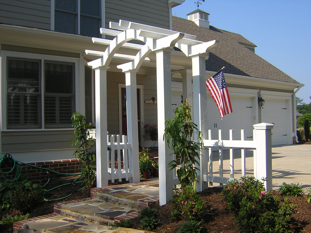 Mid-sized traditional front yard verandah in Atlanta with a vegetable garden, natural stone pavers and a pergola.