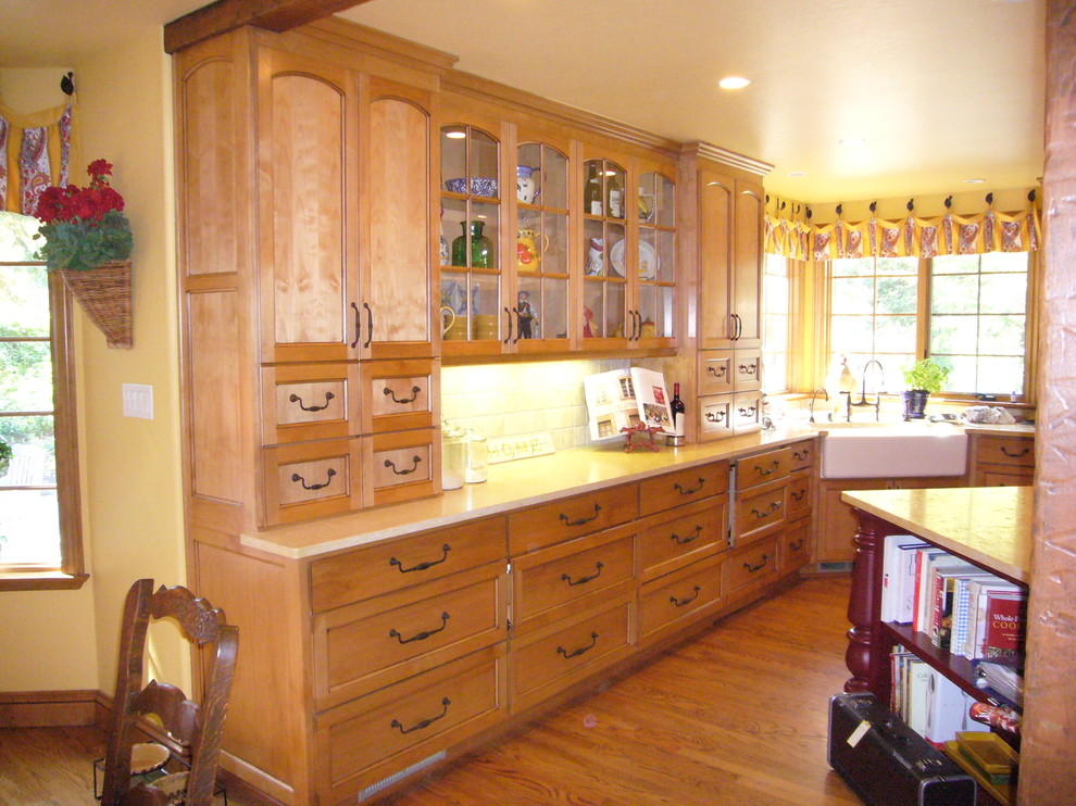 Inspiration for a mid-sized country u-shaped eat-in kitchen in San Francisco with a farmhouse sink, recessed-panel cabinets, light wood cabinets, limestone benchtops, light hardwood floors, with island and beige splashback.