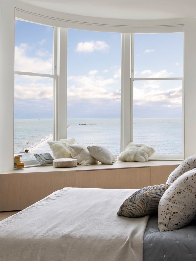 Imagen de habitación de invitados moderna de tamaño medio con paredes blancas, suelo de madera clara y suelo beige
