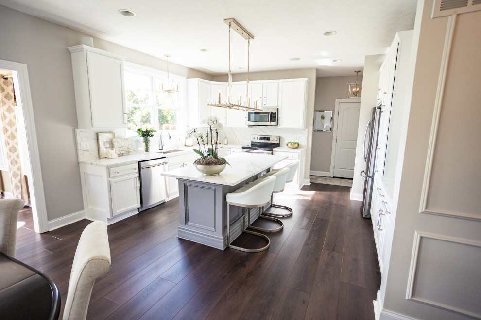 Example of a large cottage chic l-shaped vinyl floor and brown floor eat-in kitchen design in San Diego with a drop-in sink, shaker cabinets, white cabinets, granite countertops, white backsplash, marble backsplash, stainless steel appliances, an island and white countertops