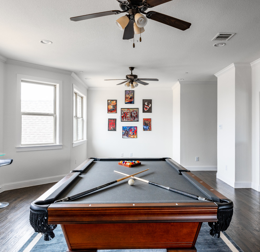 Modelo de sala de juegos en casa abierta clásica renovada con paredes blancas, suelo de madera oscura y suelo marrón