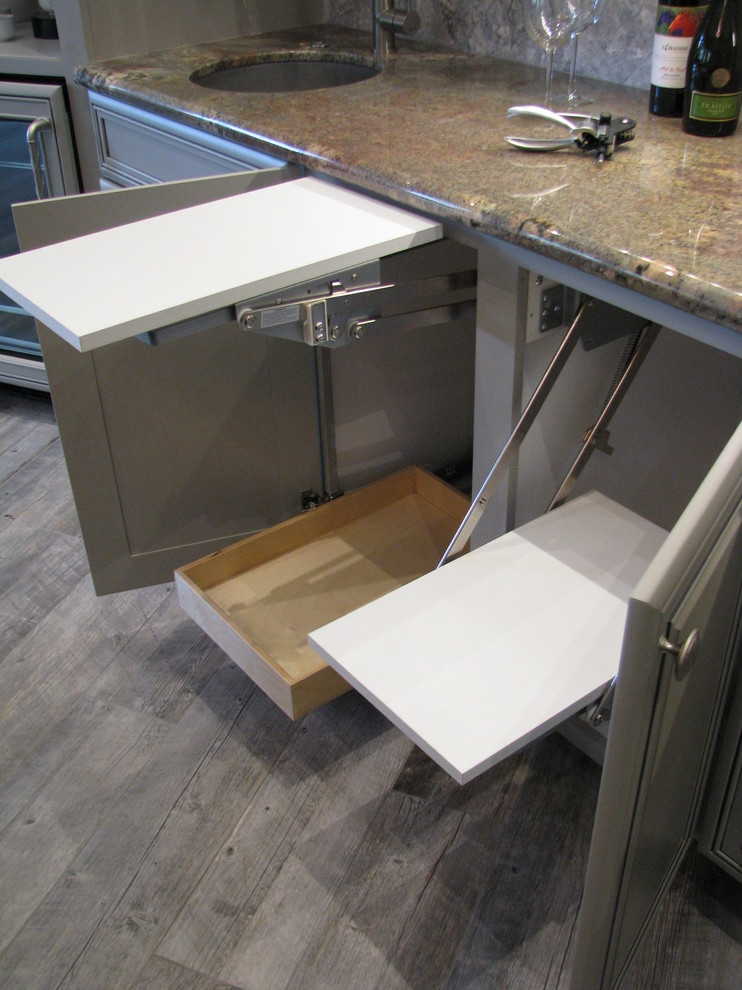 Example of a huge transitional l-shaped porcelain tile open concept kitchen design in Phoenix with an undermount sink, raised-panel cabinets, gray cabinets, granite countertops, gray backsplash, stone tile backsplash, stainless steel appliances and an island