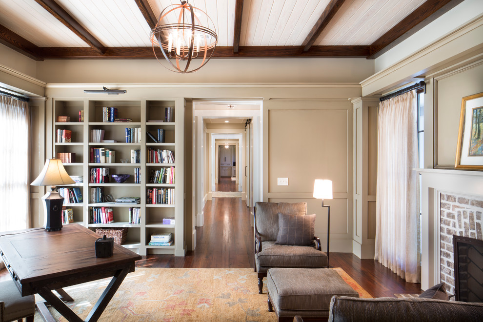 Mid-sized traditional study room in Charleston with beige walls, dark hardwood floors, a standard fireplace, a brick fireplace surround and a freestanding desk.