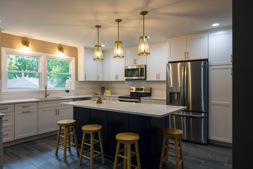 Inspiration for a large transitional u-shaped porcelain tile and gray floor open concept kitchen remodel in Chicago with an undermount sink, shaker cabinets, white cabinets, quartz countertops, white backsplash, ceramic backsplash, stainless steel appliances, an island and white countertops