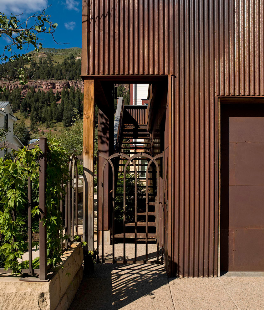 Example of a large mountain style concrete floor entryway design in Denver with a metal front door