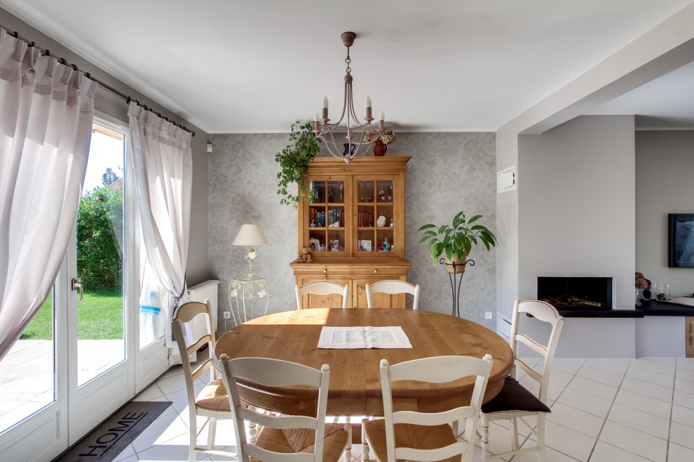 Photo of a mid-sized country open plan dining in Paris with white walls, ceramic floors and beige floor.