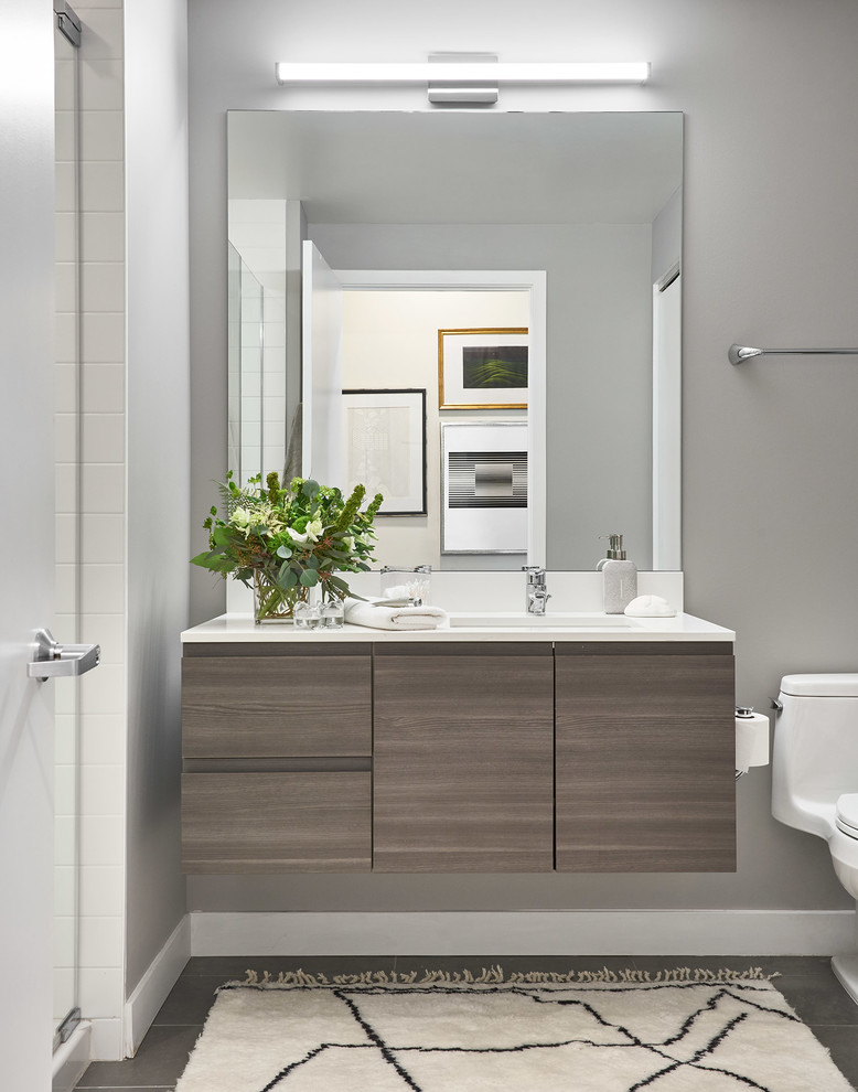 Design ideas for an eclectic master bathroom in Chicago with flat-panel cabinets, grey cabinets, grey walls, ceramic floors, engineered quartz benchtops, grey floor, a hinged shower door and white benchtops.