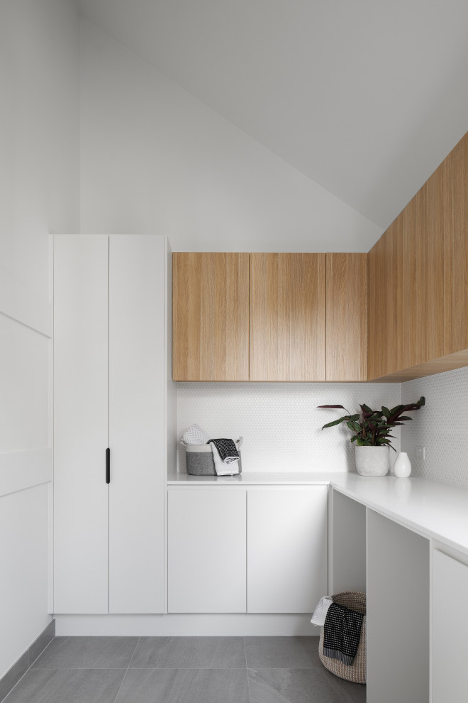 Design ideas for a large contemporary l-shaped separated utility room in Melbourne with white splashback, ceramic splashback, white walls, ceramic flooring, a side by side washer and dryer, grey floors, white worktops and a submerged sink.