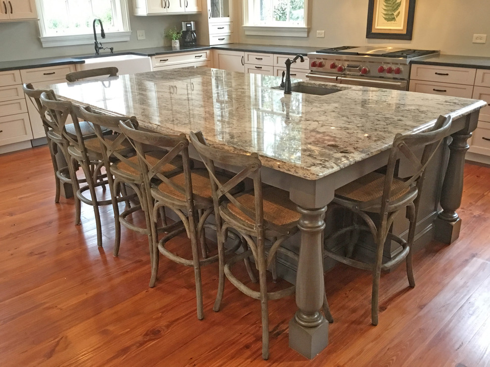 This is an example of an expansive country galley eat-in kitchen in Atlanta with a farmhouse sink, recessed-panel cabinets, white cabinets, granite benchtops, stainless steel appliances, light hardwood floors and with island.