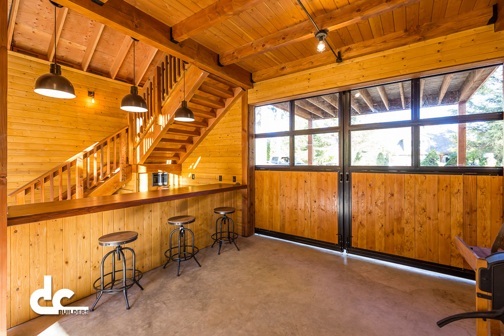 This is an example of a mid-sized country single-wall seated home bar in Portland with wood benchtops and concrete floors.