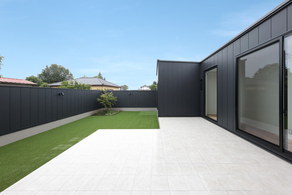 Imagen de patio minimalista grande sin cubierta en patio con suelo de baldosas