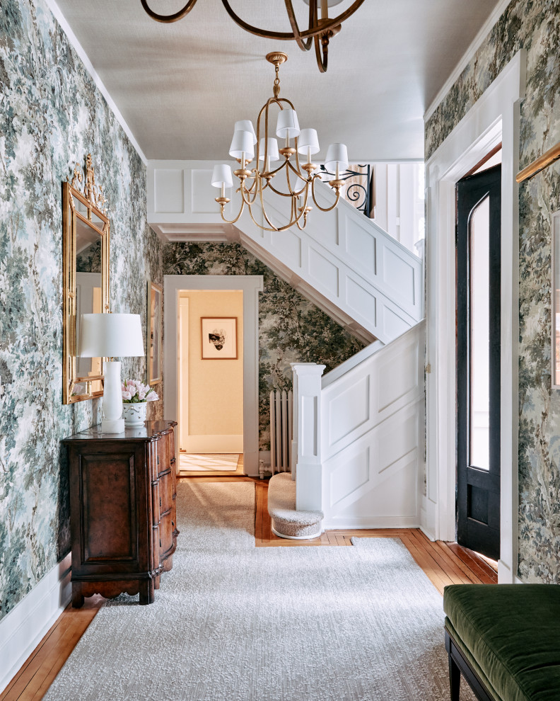 This is an example of a traditional entryway in New York with green walls, medium hardwood floors and wallpaper.