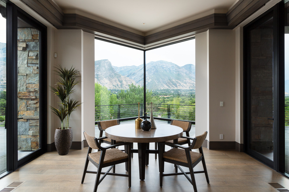 Large world-inspired dining room in Salt Lake City with banquette seating, beige walls, medium hardwood flooring and brown floors.