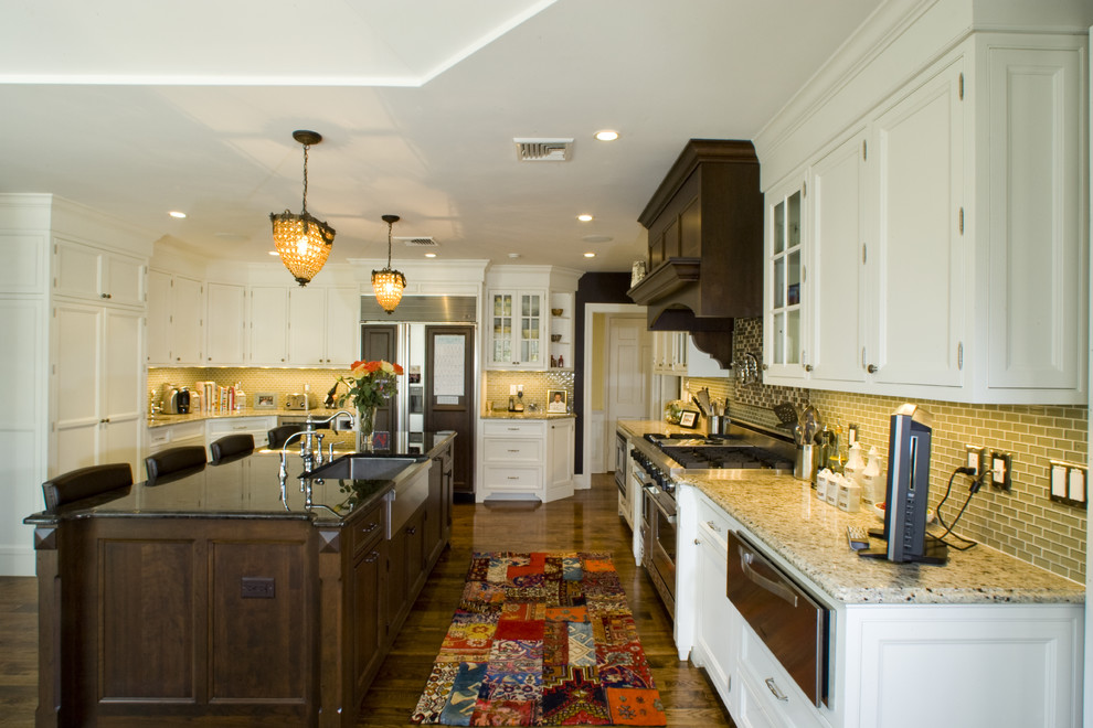 Traditional kitchen in New York with a farmhouse sink, recessed-panel cabinets, white cabinets and green splashback.