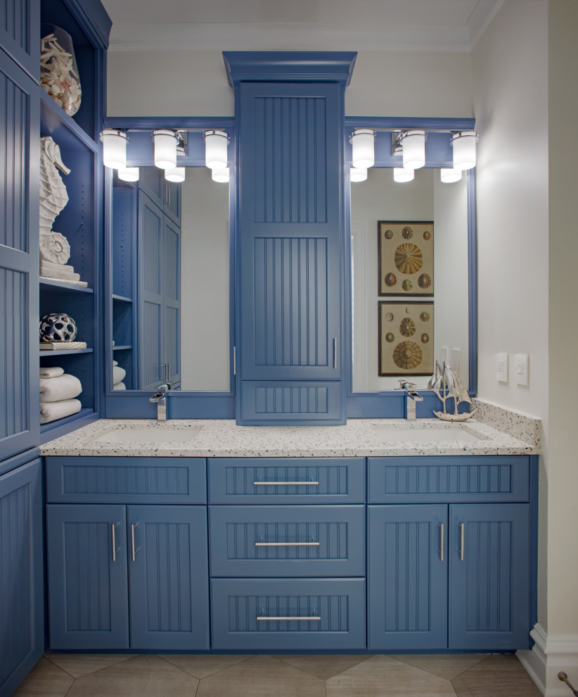 Photo of a transitional bathroom in Charleston with beaded inset cabinets, blue cabinets, an alcove shower, beige walls, travertine floors, an undermount sink, recycled glass benchtops, grey floor, a sliding shower screen and multi-coloured benchtops.