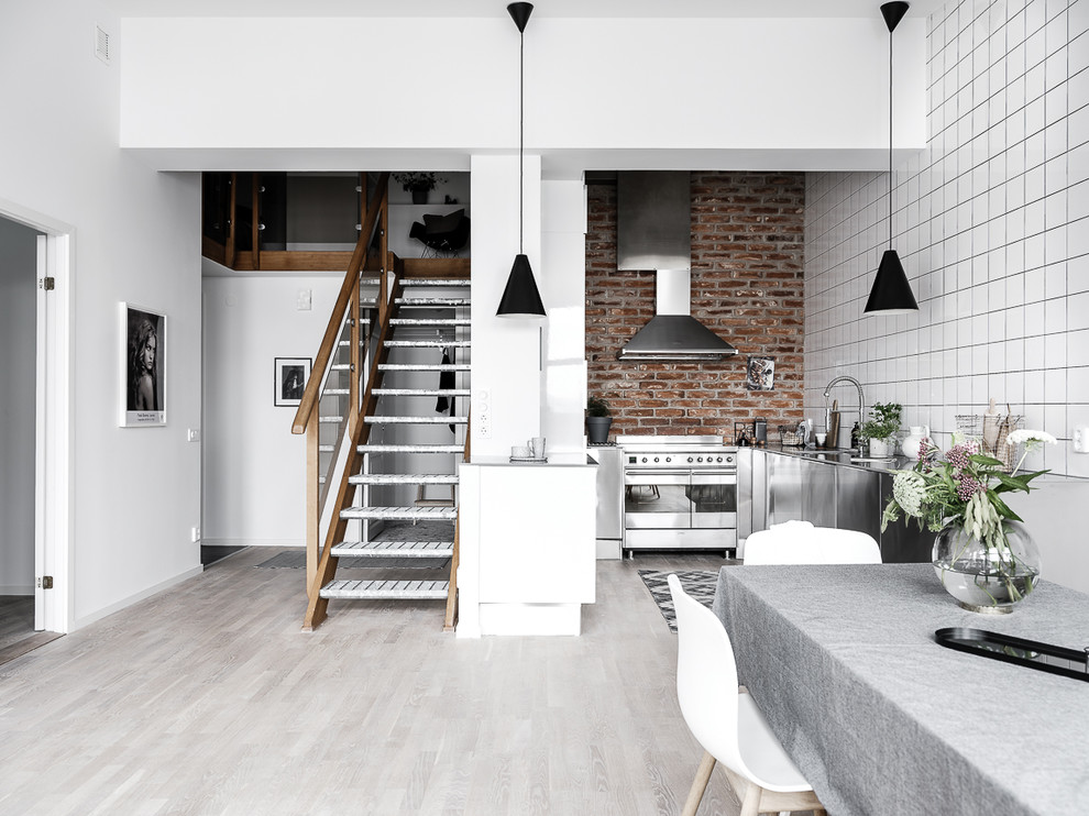 Industriell inredning av ett linjärt kök, med släta luckor och skåp i rostfritt stål