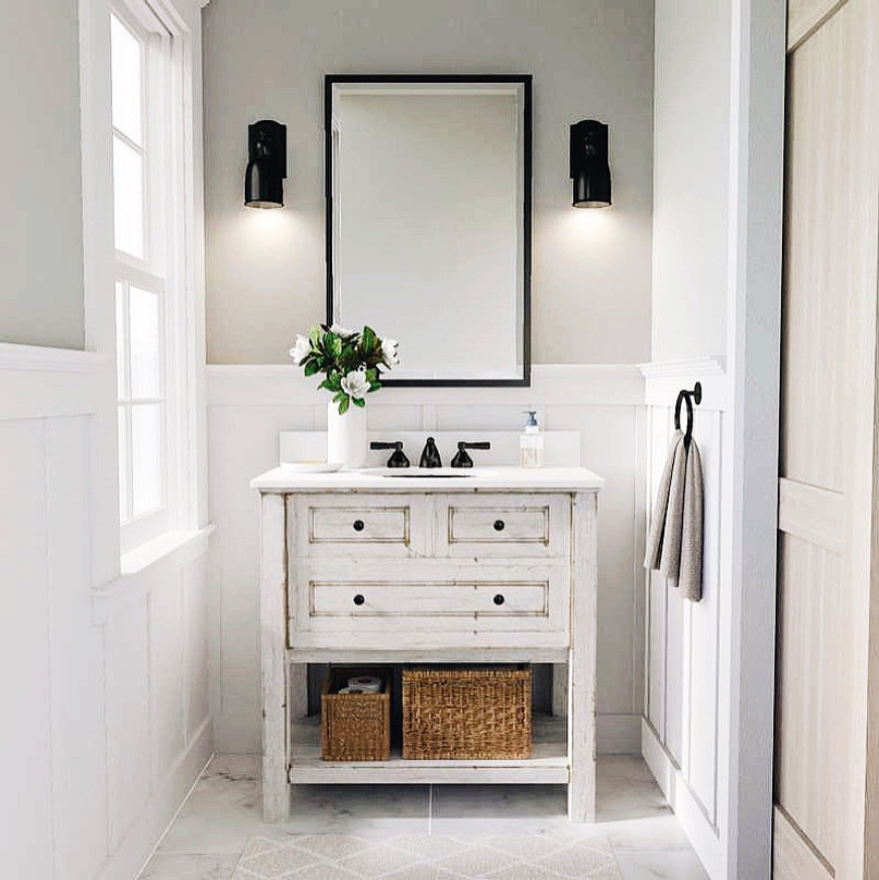 ニューヨークにある小さなトラディショナルスタイルのおしゃれなトイレ・洗面所 (淡色木目調キャビネット、グレーの壁、大理石の床、珪岩の洗面台、白い洗面カウンター、独立型洗面台、パネル壁) の写真
