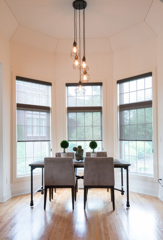 Inspiration for a transitional dining room in New York with white walls and medium hardwood floors.