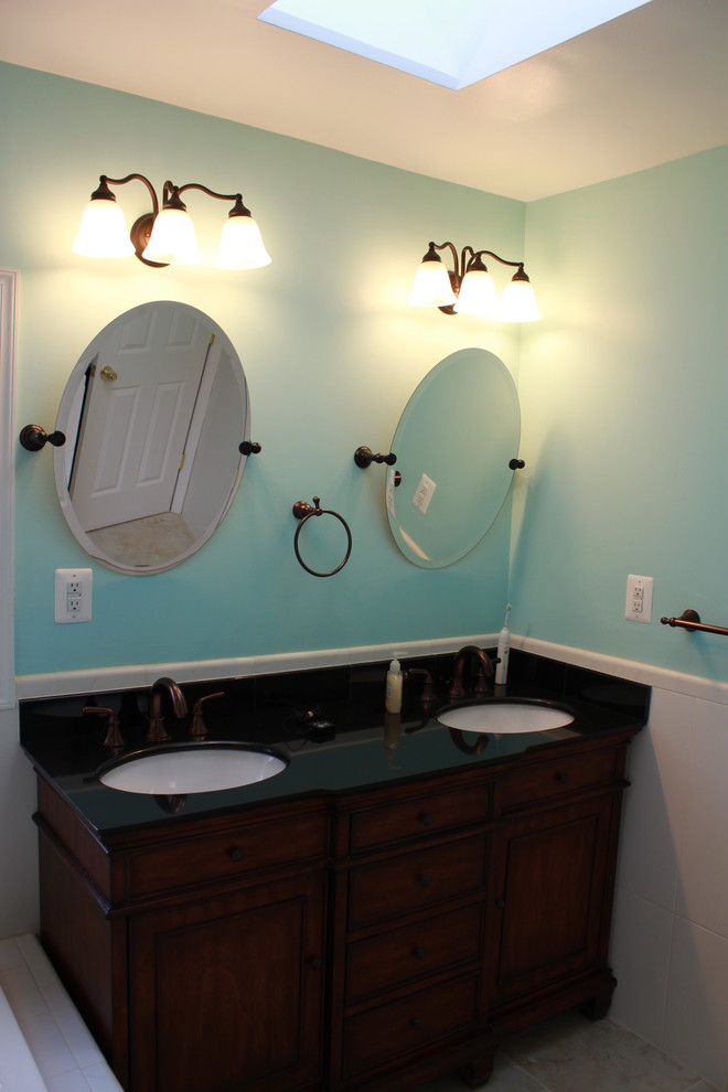 Inspiration for a large transitional white tile and ceramic tile ceramic tile drop-in bathtub remodel in DC Metro with an undermount sink, raised-panel cabinets, dark wood cabinets, granite countertops, a two-piece toilet and blue walls